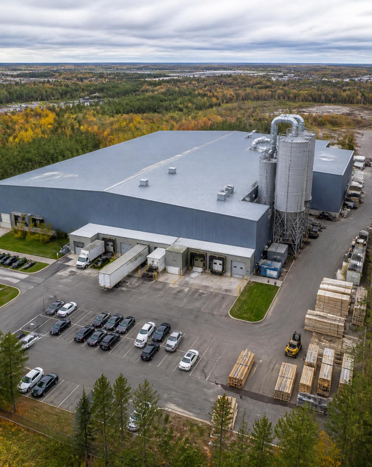 Aerial view of the 40,000 sq ft Sandha Woodworks millwork facility with dust collector and parking